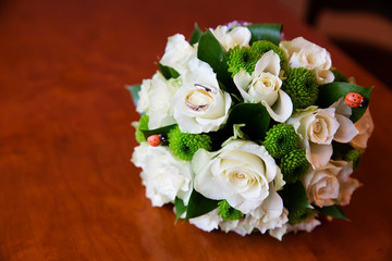 Beautiful bridal bouquet of flowers and wedding rings