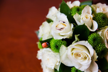 Beautiful bridal bouquet of flowers and wedding rings