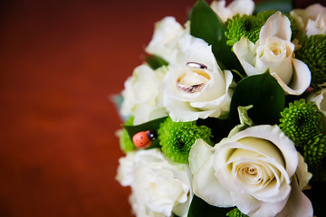 Beautiful bridal bouquet of flowers and wedding rings