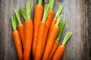 Fresh carrots bunch on rustic wooden background.