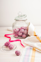 Homemade pink marshmallow on a white wooden background.