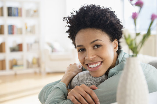 Black woman smiling on sofa