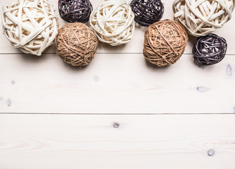 decorative balls made of rattan, lined in a row, interior border ,place for text  on wooden rustic background top view