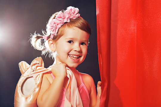 little girl ballerina ballet dancer on stage in red side scenes