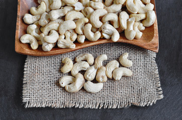 Cashews seed in a wooden plate with a dark background
