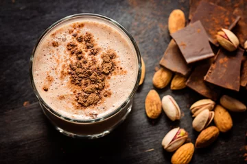 Tuinposter Milkshake koffie chocolade smoothie op een donkere achtergrond met chocolade en noten. Selectieve aandacht. Milkshake. Eiwit dieet. Gezond voedselconcept.