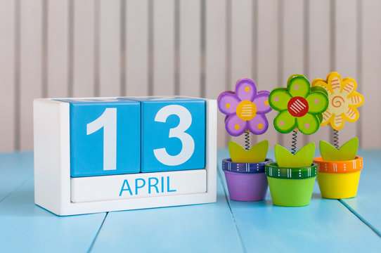 April 13th. Image of april 13 wooden color calendar on white background with flowers. Spring day, empty space for text. World Rock-n-roll Day