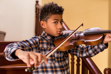 Black kid playing violin.