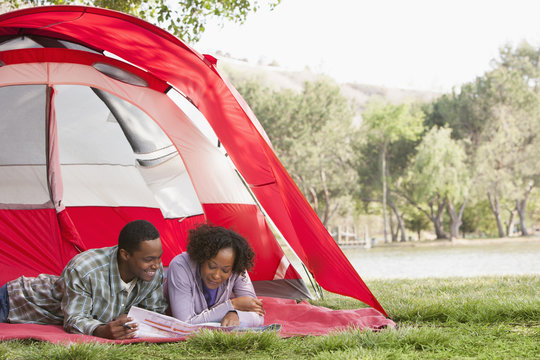 Couple reading newspaper together in tent