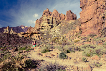 Fototapeta premium Young woman trail running in mountains on summer day