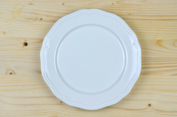 White porcelain plate on pine wood surface