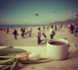 Tea cup with tulips on the wooden table opposite blurred backgro