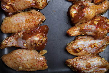 Marinated chicken wings on a black pan