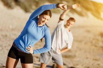 Young couple on beach training together