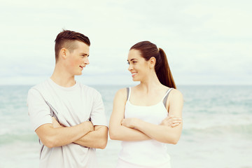 Young couple looking at each other while standing on beach