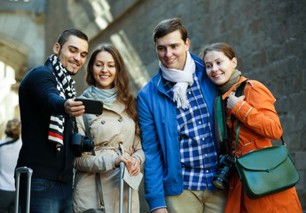 Group of friends shooting mutual portrait on cell phone