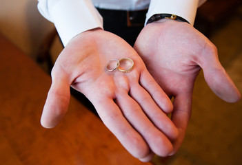 Wedding rings in the hands of the groom
