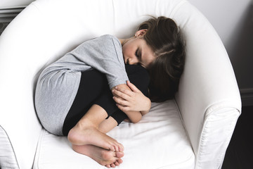 sad young girl lay on sofa