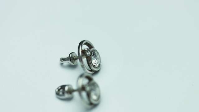 Piar of luxury white gold earrings with a diamond, isolated on a white background.