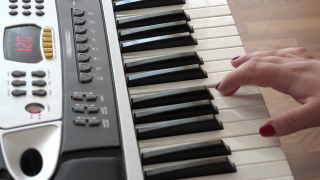 female hand improvises brilliantly on a synthesizer in a home music creates art