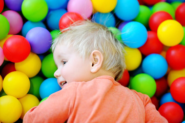 Fototapeta na wymiar Happy toddler boy in ball pit