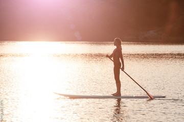 silhouette of young girl paddle boarding at sunset01