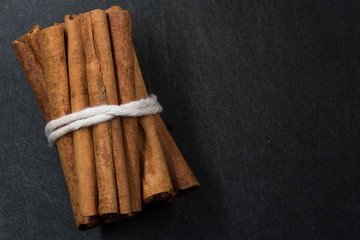 Bundle of Cinnamon Sticks Tied Together on Black Background with