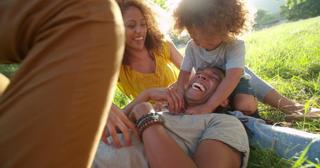 Stunning African-American family relaxing with eachother while laughing happily - Powered by Adobe