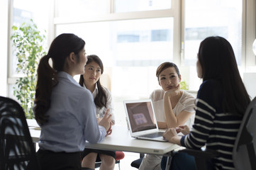 Four women have a meeting at the office