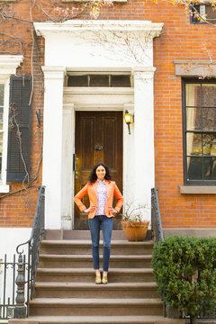 Mixed race woman smiling on front stoop