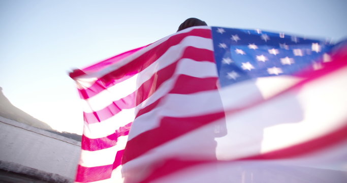 Handsome teenager girl with an American flag on a rooftop