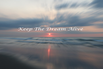 Handwritten text over sunset in zoom effect background, KEEP THE DREAM ALIVE, Inspirational and motivation