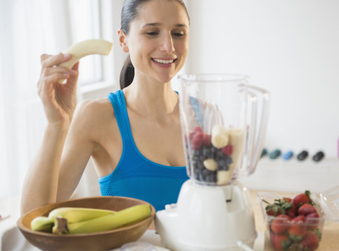 Caucasian woman blending fruit smoothie - Powered by Adobe