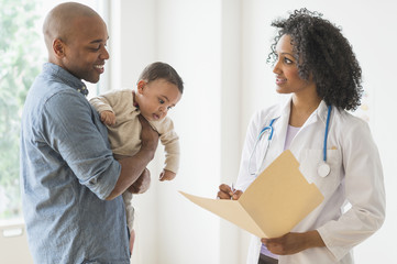 Father with baby talking to doctor