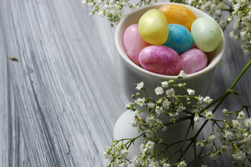 Easter Candy with spring flowers close up with copy space, selective focus.