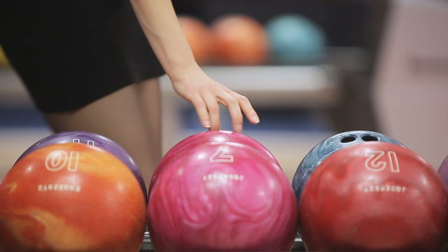 Woman takes bowling ball. Close up