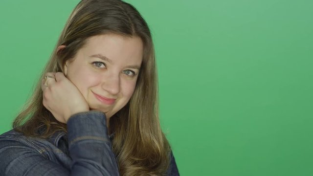 Young woman being flirty and pretending to be a tiger, on a green screen studio background