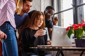 Group of international students using laptop.