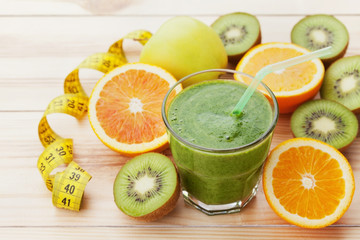 Green smoothie or juice in glass on wooden table, detox and diet food, healthy breakfast