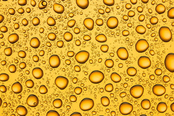 Water drops on orange glass surface texture.