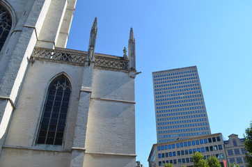 Fototapeta premium Church building and tall modern apartment building in the city of Brussels