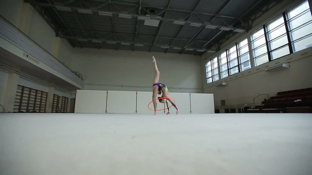 Rhythmic gymnastics: Girl training a gymnastics exercise with a hoop