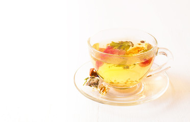 Herbal tea in a transparent cup on the white table