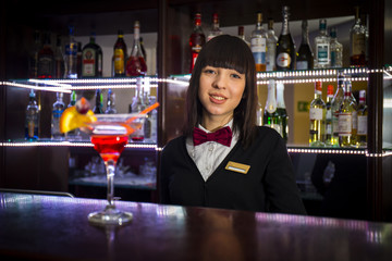 Bartender girl at night club counter offering coctail barmaid