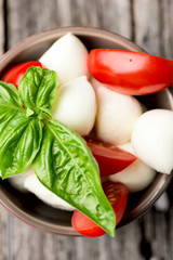Tomato and mozzarella with basil leaves in bowl