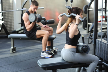 Fototapeta na wymiar Woman flexing muscles in gym