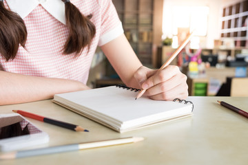 close up of young  woman writing her note