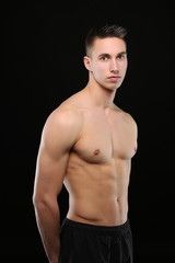 Portrait d'un bel homme torse nu sur fond noir