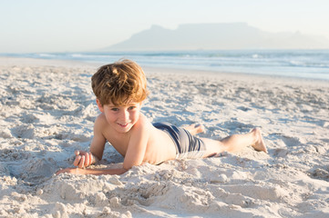 Fototapeta na wymiar Little boy lying at beach