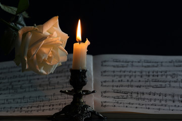 music notes, candle light and white rose